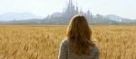 Building A Preferred Future - a person with long, mildly wavy, ash blonde hair in a horizontal thin striped shirt, looking across a field into a futuristic cityscape